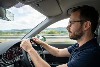 Homme en polo regardant la route dans une voiture moderne