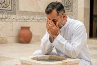 Homme effectuant les ablutions rituelles (wudu) au bassin d'une mosquée avant la prière